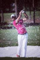 golfspeler raken een zand bunker schot foto