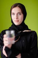 vrouw in abaya Holding een datum fruit en glas van water foto