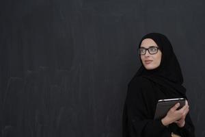 jong Arabisch zakenvrouw in traditioneel kleren of abaya Holding tablet computer foto