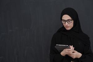 jong Arabisch zakenvrouw in traditioneel kleren of abaya Holding tablet computer foto