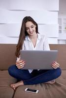 ontspannen jong vrouw Bij huis werken Aan laptop computer foto