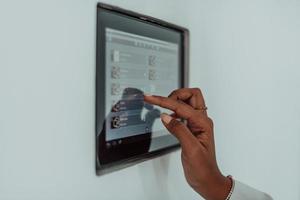 Afrikaanse vrouw gebruik makend van slim huis scherm controle systeem foto
