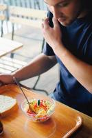 Mens aan het eten gezond voedsel het een restaurant foto