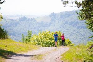 jong paar jogging Aan zonnig dag Bij natuur foto