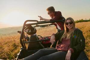 groep jong gelukkig mensen genieten van mooi zonnig dag terwijl het rijden een uit weg buggy auto foto