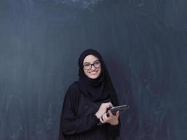 jong moslim bedrijf vrouw gebruik makend van tablet computer foto