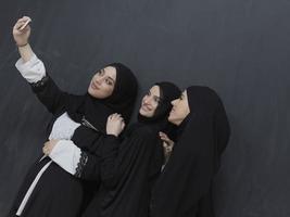 portret van Arabisch Dames vervelend traditioneel kleren of abaya nemen selfie foto