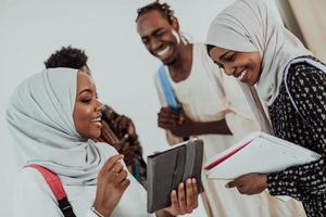 Afrikaanse vrouw leerling met groep van vrienden in achtergrond vervelend traditioneel Islamitisch hijab kleren. selectief focus foto