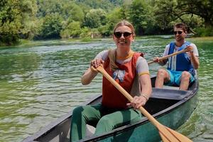 vrienden zijn kanoën in een wild rivier- foto