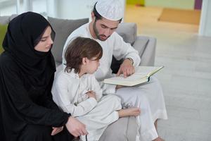 jong moslim familie lezing koran gedurende Ramadan foto