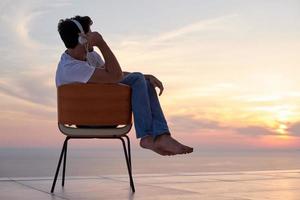 ontspannen jong Mens Bij huis Aan balkon foto