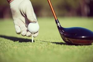 golf speler plaatsen bal Aan tee foto