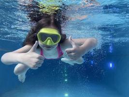 glimlachen kind in stofbril zwemmen, duiken in de zwembad met pret - springen diep naar beneden onderwater. gezond levensstijl, mensen water sport werkzaamheid Aan zomers. foto