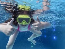 glimlachen kind in stofbril zwemmen, duiken in de zwembad met pret - springen diep naar beneden onderwater. gezond levensstijl, mensen water sport werkzaamheid Aan zomers. foto