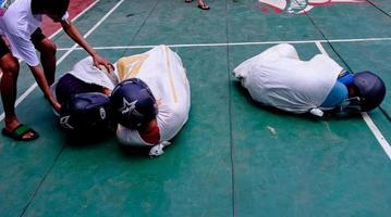 divers wedstrijden naar herdenken Indonesië's onafhankelijkheid dag waren gedragen uit in een gemakkelijk maar nog steeds levendig manier. zak ras, kraker aan het eten wedstrijd, sleepboot van oorlog, areca beklimming wedstrijd. foto