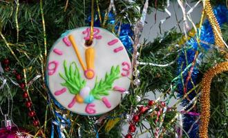 detailopname van een Kerstmis boom met ornamenten van kerstballen, sneeuwvlokken, klatergoud, slingers en een groot peperkoek-klok foto