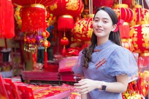 aziatisch mooi meisje in lang haar draagt een grijze chinese jurk met chinees nieuwjaarsthema. foto