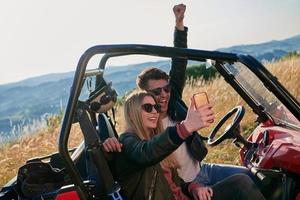 paar genieten van mooi zonnig dag nemen selfie afbeelding terwijl het rijden een uit weg buggy foto