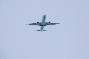 reclame vliegtuig vliegend onder blauw luchten en aankomen Bij de luchthaven foto