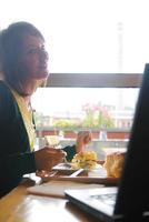 vrouw aan het eten Bij een restaurant foto