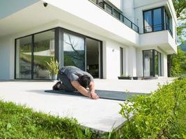 Mens aan het doen ochtend- yoga opdrachten foto