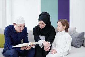 moslim familie lezing koran en bidden Bij huis foto