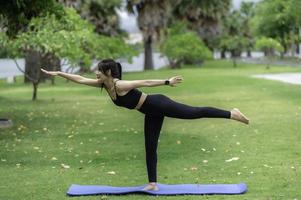 portret van jong Aziatisch vrouw Speel yoga in de openbaar park foto