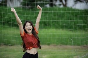 portret van jong Aziatisch vrouw slijtage voetbal speler foto