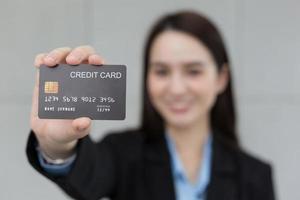 Aziatisch bedrijf werken vrouw shows credit kaart Gesloten omhoog in financieel keuze concept. foto