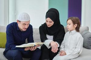 jong moslim familie lezing koran gedurende Ramadan foto