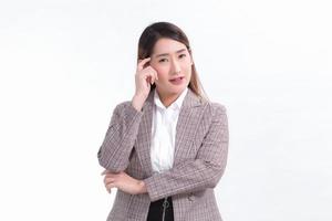 Aziatische zakenvrouw in formeel pak denkt iets op een witte achtergrond. foto