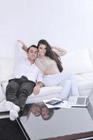 blij paar kom tot rust en werk Aan laptop computer Bij modern huis foto