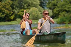 vrienden zijn kanoën in een wild rivier- foto