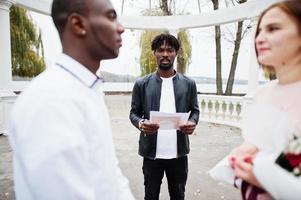 bruiloft verloving ceremonie met pastoor. gelukkig multi-etnisch paar in liefde verhaal. relaties van Afrikaanse Mens en wit Europese vrouw. foto