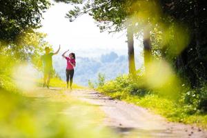 jogging paar geven hoog vijf naar elk andere Aan zonnig dag Bij natuur foto