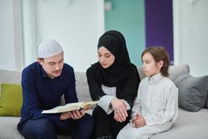 jong moslim familie lezing koran gedurende Ramadan foto