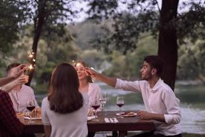 vrienden hebben picknick Frans avondeten partij buitenshuis gedurende zomer vakantie foto