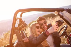 jong paar nemen selfie afbeelding terwijl het rijden een uit weg buggy foto