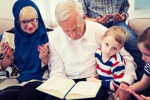 modern moslim grootouders met kleinkinderen lezing koran foto