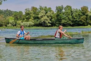 vrienden zijn kanoën in een wild rivier- foto