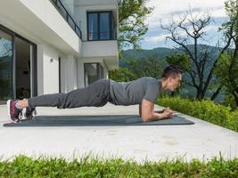 Mens aan het doen ochtend- yoga opdrachten foto