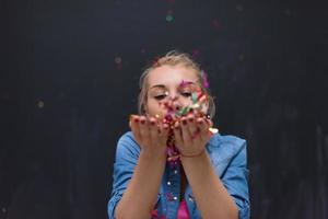 vrouw blazen confetti in de lucht foto