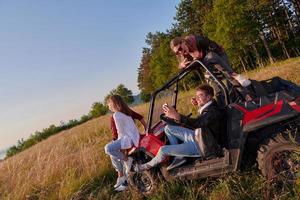 groep jong gelukkig mensen genieten van mooi zonnig dag terwijl het rijden een uit weg buggy auto foto