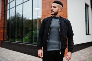 portret van elegant Arabisch baard Mens slijtage grijs coltrui en zwart jas. Arabisch model- jongen. foto