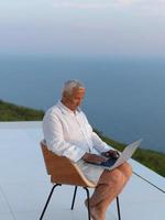 ontspannen senior Mens Aan balkon foto