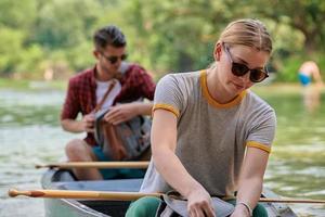 vrienden zijn kanoën in een wild rivier- foto