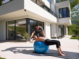 vrouw en persoonlijk trainer aan het doen oefening met pilates bal foto