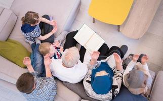 top visie van modern moslim grootouders met kleinkinderen lezing koran foto