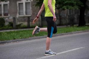 vrouw loper opwarming omhoog en uitrekken voordat ochtend- opleiding foto