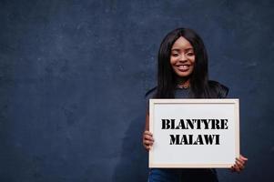 Afrikaanse vrouw houden wit bord met blantyre Malawi inscriptie. meest dichtbevolkt stad in Afrika concept. foto